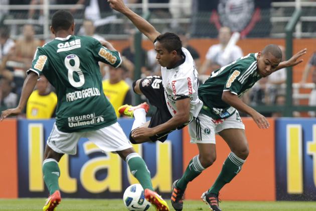 Corinthians' Jorge Henrique, center, fights for a ball with Palmeiras' Marcio Araujo, left, and Patrick during the last round of the Brazilian soccer league in Sao Paulo, Brazil, Sunday, Dec. 4, 2011. The match ended 0-0 and Corinthians became Brazil's 2011 soccer champions. (AP Photo/Andre Penner)