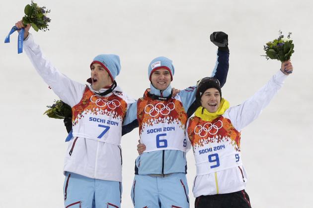 Norway's gold medal winner Joergen Graabak is flanked by Norway's silver medal winner Magnus Hovdal Moan, left, and Germany's bronze medal winner Fabian Riessle during flower ceremony of the Nordic combined individual Gundersen large hill competition at the 2014 Winter Olympics, Tuesday, Feb. 18, 2014, in Krasnaya Polyana, Russia. (AP Photo/Matthias Schrader)