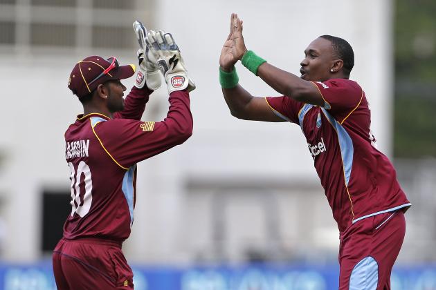 West Indies' Dwayne Bravo, right, highs five with his wicket keeper Denesh Ramdin after they took the wicket of Sri Lanka's opener Upul Tharanga, who was caught behind for 25 runs, during their Tri-Nation Series cricket match in Kingston, Jamaica, Friday, June 28, 2013. (AP Photo/Andres Leighton)