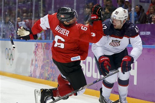 Canada defenseman Shea Weber, left, trips over USA forward David Backes during the third period of a men's semifinal ice hockey game at the 2014 Winter Olympics, Friday, Feb. 21, 2014, in Sochi, Russia. (AP Photo/Julio Cortez)