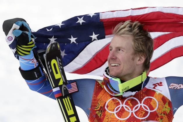 Men's giant slalom gold medalist Ted Ligety of the United States poses for photographers with the American flag on the podium at the Sochi 2014 Winter Olympics, Wednesday, Feb. 19, 2014, in Krasnaya Polyana, Russia.(AP Photo/Charles Krupa)