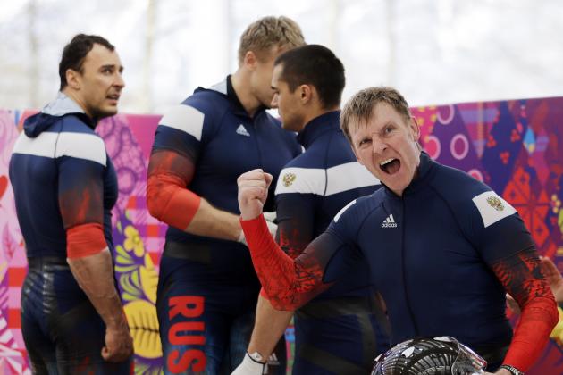 The team from Russia RUS-1, with Alexander Zubkov, foreground, Alexey Negodaylo, Dmitry Trunenkov, and Alexey Voevoda, react after their third run during the men's four-man bobsled competition final at the 2014 Winter Olympics, Sunday, Feb. 23, 2014, in Krasnaya Polyana, Russia. (AP Photo/Jae C. Hong)