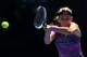 MELBOURNE, AUSTRALIA - JANUARY 22: Victoria Azarenka of Belarus plays a backhand in her quarterfinal match against Agnieszka Radwanska of Poland during day 10 of the 2014 Australian Open at Melbourne Park on January 22, 2014 in Melbourne, Australia. (Photo by Mark Kolbe/Getty Images)