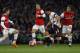 Liverpool's Luis Suarez, second right, is marked by Arsenal's Mathieu Flamini, right, Nacho Monreal, left, and Mesut Ozil during their English FA Cup fifth round soccer match at Emirates Stadium in London, Sunday, Feb. 16, 2014. (AP Photo/Sang Tan)