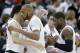 Michigan State's Adreian Payne, center, and Branden Dawson, right, are greeted with hugs as they head to the bench in the final moments of the second half during the second round of the NCAA men's college basketball tournament against Delaware in Spokane, Wash., Thursday, March 20, 2014. Michigan State won 93-78. (AP Photo/Elaine Thompson)