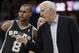 San Antonio Spurs coach Gregg Popovich talks to Patty Mills during the second quarter of an NBA basketball game against the Cleveland Cavaliers on Tuesday, March 4, 2014, in Cleveland. (AP Photo/Mark Duncan)