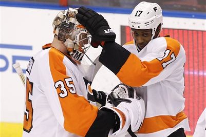 CORRECTS SCORE TO 5-2 - Philadelphia Flyers goalie Steve Mason (35) and right wing Wayne Simmonds (17) celebrate after defeating the Florida Panthers 5-2 in an NHL hockey game in Sunrise, Fla., on Tuesday, April 8, 2014. (AP Photo/Terry Renna)