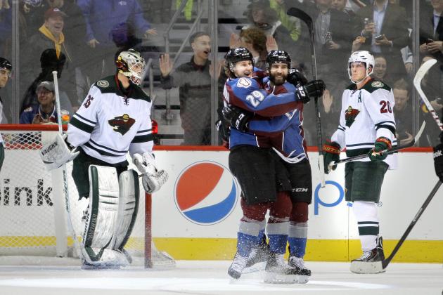 Colorado Avalanche's Nathan MacKinnon (29) hugs Maxime Talbot after he scored during the second period of an NHL hockey game Thursday, Jan. 30, 2014, in Denver. Minnesota Wild goalie Darcy Kuemper, left, and Wild's Ryan Suter, right, react in the background. (AP Photo/Barry Gutierrez)