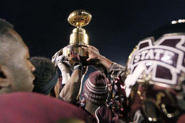 Mississippi State football players celebrate as they carry the Egg Bowl trophy after they defeated Mississippi 17-10 in overtime in an NCAA college football game, Thursday, Nov. 28, 2013, in Starkville, Miss. (AP Photo/Rogelio V. Solis)