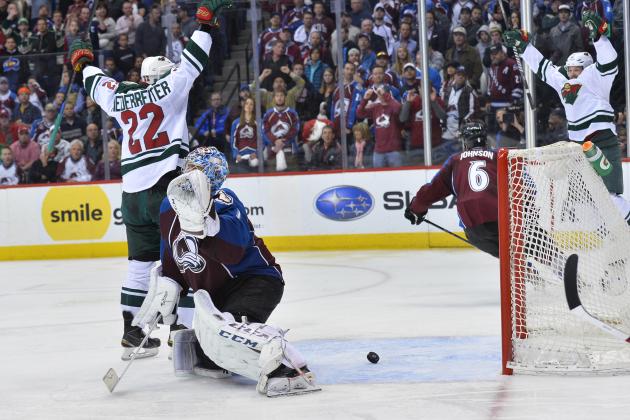 The puck bounces out of the net after Colorado Avalanche goalie Semyon Varlamov, second from left, of Russia lets the winning goal slip past off the stick of Minnesota Wild right wing Nino Niederreiter (22) of Switzerland in the overtime period during Game 7 of an NHL hockey first-round playoff series on Wednesday, April 30, 2014, in Denver. Minnesota won 5-4 to win the series. (AP Photo/Jack Dempsey)