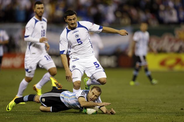 Bosnia's Sead Kolasinac (5) leaps over Argentina's Rodrigo-Palacio, bottom, during the first half of an international friendly soccer match Monday, Nov. 18, 2013, in St. Louis. (AP Photo/Jeff Roberson)