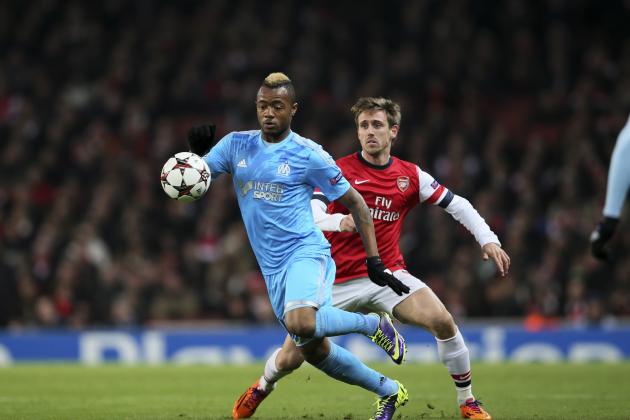 Marseille's Jordan Ayew, left, competes for the ball with Arsenal's Nacho Monorail during the Group F Champions League soccer match between Arsenal and Marseille at the Emirates stadium in London, Tuesday, Nov. 26, 2013. (AP Photo/Alastair Grant)