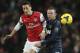 FILE - In this Feb. 12, 2014, file photo, Arsenal's Mesut Ozil, left, nudges the ball from Manchester United's Wayne Rooney during their English Premier League soccer match in London. Less than a year after pushing to leave Manchester United, Rooney committed his long-term future to the struggling Premier League champion on Friday, Feb. 21, by signing a lucrative contract through June 2019. (AP Photo/Alastair Grant, File)