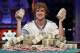 Ryan Riess holds up two bricks of $100 bills after winning the World Series of Poker Final Table, Tuesday, Nov. 5, 2013, in Las Vegas. Riess defeated runner up Jay Farber for an $8.4 million payout (AP Photo/Julie Jacobson)