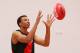 MELBOURNE, AUSTRALIA - FEBRUARY 14: Young Australian basketball player Dante Exum marks the ball after being presented a jumper by Joe Daniher of the Bombers during an Essendon Bombers AFL media session at True Value Solar Centre on February 14, 2014 in Melbourne, Australia. (Photo by Michael Dodge/Getty Images)