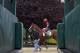 Kentucky Derby winner California Chrome, with exercise rider Willie Delgado aboard, follows assistant trainer Alan Sherman past a starting gate after a workout at Pimlico Race Course in Baltimore, Wednesday, May 14, 2014. The Preakness Stakes horse race is scheduled to take place May 17. (AP Photo)