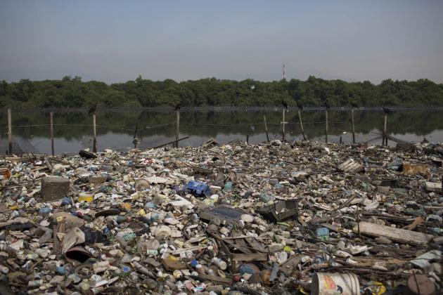 In this May 15, 2014 photo, trash floats on a polluted water channel that flows into the Guanabara Bay in Rio de Janeiro, Brazil. In its 2009 Olympic bid, officials promised that the city's waterways would be cleaned up but Brazil will not make good on its commitment to clean up Rio de Janeiro's sewage-filled Guanabara Bay by the 2016 Olympic Games. Little progress has been made on the clean up, and with just over two years to go until the Olympics, nearly 70 percent of the sewage in the metropolitan area of 12 million inhabitants continues to flow untreated, along with thousands of tons of garbage daily, into area rivers, the bay and even Rio's famed beaches like Copacabana and Ipanema. (AP Photo/Felipe Dana)