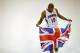 Atlanta Hawks' Al Horford holds a British flag given to him by a photographer before posing for a photo during their NBA basketball media day, Monday, Sept. 30, 2013, in Atlanta. The flag references the team's trip to London in January to face the Brooklyn Nets. (AP Photo/David Goldman)