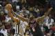 Miami Heat's LeBron James (6) fouls San Antonio Spurs' Tim Duncan (21) as he tries to steal the ball during the second half of an NBA basketball game in Miami, Sunday, Jan. 26, 2014. The Heat won 113-101. (AP Photo/J Pat Carter)