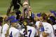 Florida pitcher Hannah Rogers holds the trophy as the team celebrates following an NCAA Women's College World Series softball tournament game against Alabama in Oklahoma City, Tuesday, June 3, 2014. Florida won the game 6-3 and took the title. (AP Photo/Sue Ogrocki)