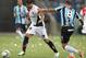 Ever Banega of Argentina's Newell's Old Boys, left, fights for the ball with Edinho of Brazil's Gremio during their Copa Libertadores soccer match in Porto Alegre, Brazil, Thursday, March 13, 2014. (AP Photo/Nabor Goulart)