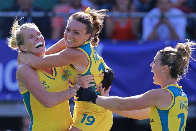 Australia's Georgie Parker, center, and Australia's Kellie White, right, hug Jodie Kenny, left, who scored the decisive goal in the shootout during the Field Hockey World Cup semifinal match women between the U.S. and Australia in The Hague, Netherlands, Thursday, June 12, 2014. The match ended in a 2-2 draw, Australia won the shootout 3-1 and continues to the final. (AP Photo/Peter Dejong)
