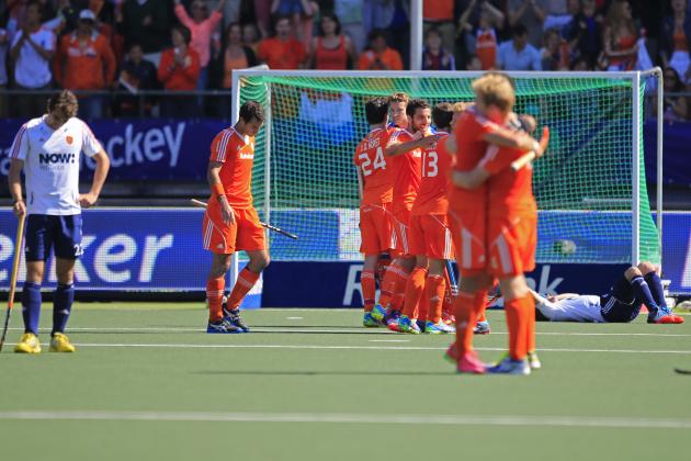 England players, left, and right, look dejected as the Dutch team celebrates winning the Field Hockey World Cup semifinal match men between the Netherlands and England in The Hague, Netherlands, Friday, June 13, 2014. The Netherlands won the match with a 1-0 score and continues to play the final on Sunday. (AP Photo/Peter Dejong)