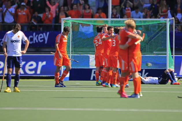 England players, left, and right, look dejected as the Dutch team celebrates winning the Field Hockey World Cup semifinal match men between the Netherlands and England in The Hague, Netherlands, Friday, June 13, 2014. The Netherlands won the match with a 1-0 score and continues to play the final on Sunday. (AP Photo/Peter Dejong)