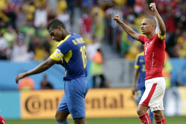 Switzerland's Goekhan Inler, right, celebrates his team's 2-1 victory over Ecuador during the group E World Cup soccer match between Switzerland and Ecuador at the Estadio Nacional in Brasilia, Brazil, Sunday, June 15, 2014. (AP Photo/Marcio Jose Sanchez)