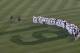 San Diego Padres players stand in right field observing 19 seconds of silence in honor of Hall of Fame player Tony Gwynn during ceremonies prior to a baseball game against the Seattle Mariners Wednesday, June 18, 2014, in San Diego. Gwynn died Monday of cancer at the age of 54. (AP Photo/Lenny Ignelzi)