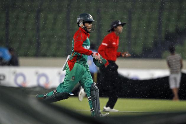 Bangladesh's captain Mushfiqur Rahim, foreground, runs back to the pavilion when play was halted due to rain during the third one-day International cricket match against India in Dhaka, Bangladesh, Thursday, June 19, 2014. (AP Photo/A.M. Ahad)