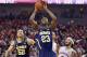 Michigan's Caris LeVert (23) goes for a layup as Nebraska's Terran Petteway (5) and Michigan's Jordan Morgan (52) look on in the first half of an NCAA college basketball game in Lincoln, Neb., Thursday, Jan. 9, 2014. (AP Photo/Nati Harnik)