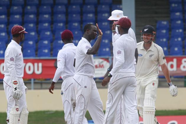 West Indies bowler Kemar Roach, center, celebrates with teammates after taking the wicket of New Zealand's Mark Craig who was caught behind by West Indies' Denesh Ramdin for 67 runs during the second innings on the last day of their second cricket Test match in Port of Spain, Trinidad, Friday, June 20, 2014. (AP Photo/Arnulfo Franco)