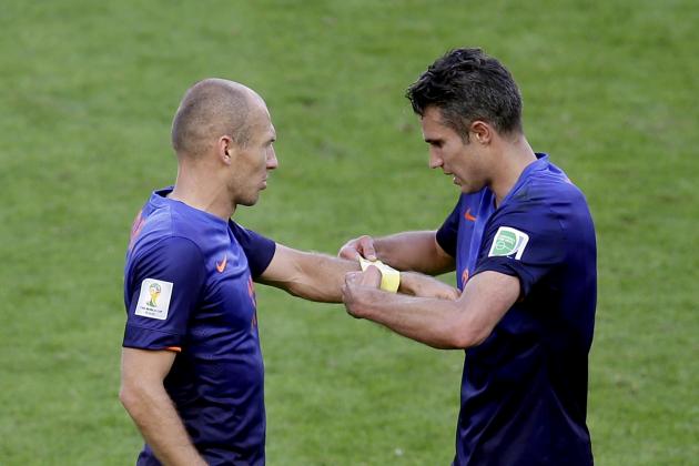 Netherlands' Robin van Persie, right, gives the captain's arm band to his teammate Arjen Robben before he is substituted during the group B World Cup soccer match between Australia and the Netherlands at the Estadio Beira-Rio in Porto Alegre, Brazil, Wednesday, June 18, 2014.  (AP Photo/Michael Sohn)