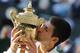 Novak Djokovic of Serbia kisses the trophy after defeating Roger Federer of Switzerland in the men's singles final at the All England Lawn Tennis Championships in Wimbledon, London, Sunday July 6, 2014. (AP Photo/Ben Curtis)