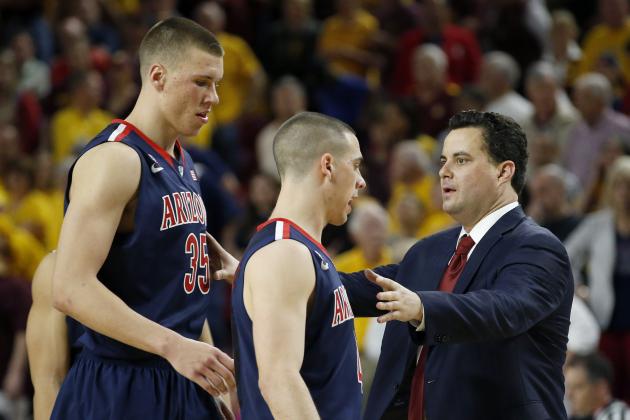 Arizona head coach Sean Miller, right, talks with his players Kaleb Tarczewski (35), and T.J. McConnell during the first overtime of an NCAA college basketball game against Arizona State, Friday, Feb. 14, 2014, in Tempe, Ariz.  Arizona State defeated Arizona 69-66 in double overtime. (AP Photo/Ross D. Franklin)