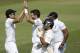 England's James Anderson, center, celebrates with captain Alastair Cook, left, beside Chris Jordan after taking the wicket of India's captain and wicketkeeper Mahendra Singh Dhoni, second right, during the fourth day of the third cricket test match of the series between England and India at The Ageas Bowl in Southampton, England, Wednesday, July 30, 2014. (AP Photo/Matt Dunham)