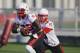Nebraska quarterback Johnny Stanton, right, hands off the ball to running back Imani Cross during Nebraska's first day of NCAA college football practice in Lincoln, Neb., Monday, Aug. 4, 2014. (AP Photo/Nati Harnik)