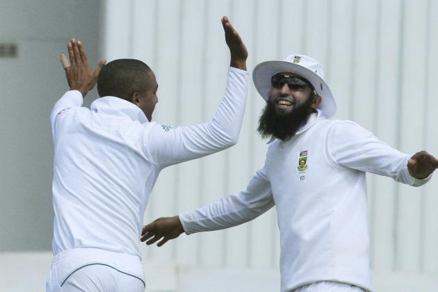 South African players  Dane Piedt, left, and Hashim Amla celebrate the wicket of Zimbabwean batsman Brendan Taylor during the cricket Test match against South Africa at the Harare Sports club, in Harare Zimbabwe Tuesday, Aug. 12, 2014. (AP Photo/Tsvangirayi Mukwazhi)