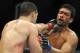 Jul 5, 2014; Las Vegas, NV, USA; Chris Weidman (red gloves) grabs Lyoto Machida (blue gloves) by the throat during a middleweight title bout at Mandalay Bay Events Center. Mandatory Credit: Stephen R. Sylvanie-USA TODAY Sports
