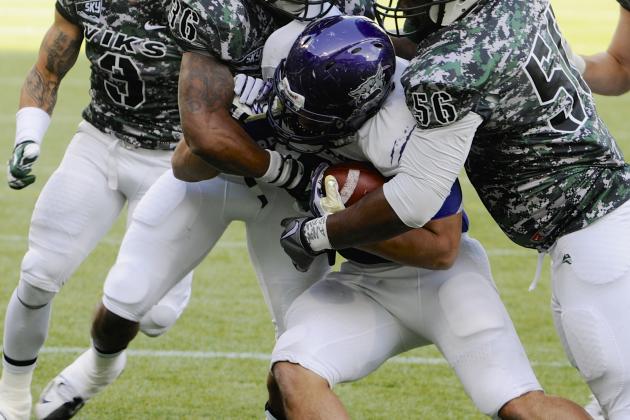 Weber State's Bo Bolen (8) is tackled by Portland State's David Edgerson (3), Aaron Sibley (36), Jeremy Boone (56) and Jaycob Shoemaker (6) during the first half of an NCAA college football game in Portland, Ore., Saturday Nov 2, 2013. (AP Photo/Greg Wahl-Stephens)