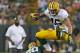 Green Bay Packers tight end Colt Lyerla jumps over defensive back Jumal Rolle during the Family Night practice of NFL football training camp Saturday, Aug. 2, 2014, in Green Bay, Wis. (AP Photo/Matt Ludtke)