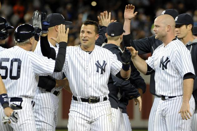 New York Yankees' Martin Prado, center, is mobbed by teammates after his game-winning RBI single that scored Ichiro Suzuki in the ninth inning of a baseball game against the Chicago White Sox at Yankee Stadium on Friday, Aug. 22, 2014, in New York. (AP Photo/Kathy Kmonicek)