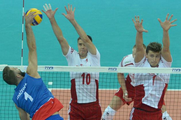 Serbia's Nikola Kovacevic, left, spikes the ball against Poland's Mariusz Wlazly, center, and Piotr Nowakowski during their game opening the FIVB Men's Volleyball World Championships at the National Stadium in Warsaw, Poland, Saturday, Aug. 30, 2014. (AP Photo/Alik Keplicz)