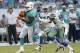 Miami Dolphins running back Knowshon Moreno (28) runs with the ball ahead of Dallas Cowboys outside linebacker Anthony Hitchens (59) during the first half of an NFL preseason football game, Saturday, Aug. 23, 2014 in Miami Gardens, Fla. (AP Photo/Lynne Sladky)