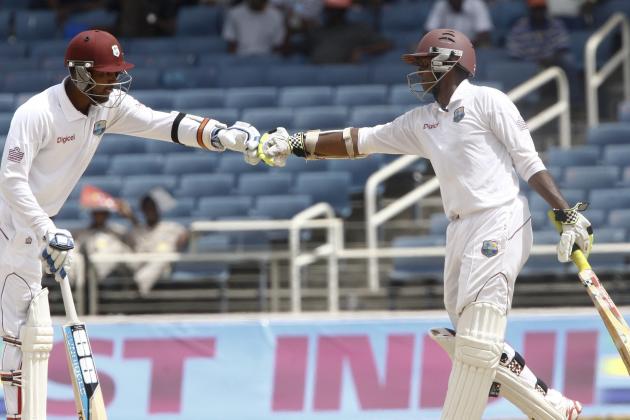 West Indies captain Denesh Ramdin, left, and batting partner Shivnarine Chanderpaul fist bump with gloved hands during the third day of their first cricket Test match against New Zealand in Kingston, Jamaica, Tuesday, June 10, 2014. (AP Photo/Arnulfo Franco)