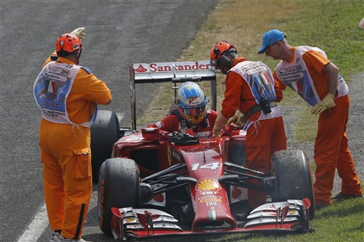 Ferrari driver Fernando Alonso of Spain leaves his car after failing to complete the during the Italian Formula One Grand Prix at the Monza racetrack, in Monza, Italy, Sunday, Sept. 7, 2014. (AP Photo/Antonio Calanni)