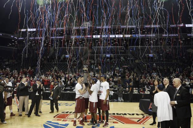FILE - In this March 16, 2014, file photo, members of the Saint Joseph's team hold the championship trophy after an NCAA college basketball game against VCU in the championship round of the Atlantic 10 Conference tournament at the Barclays Center in New York. The Atlantic 10 was scheduled to play its tournament there through 2017, but will move in exchange for playing an ACC/A-10 doubleheader at Barclays during the 2015-16, 2016-17 and 2017-18 seasons. The A-10 tournament will then return to Barclays for three years starting in 2019. (AP Photo/Seth Wenig, File)
