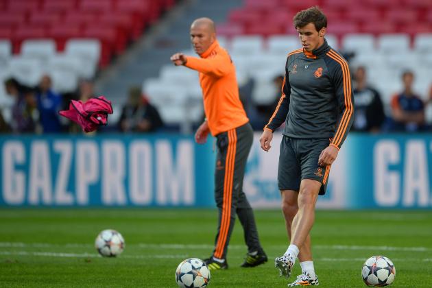 LISBON, PORTUGAL - MAY 23:  Gareth Bale of Real Madrid kicks the ball as Assistant coach Zinedine Zidane of Real Madrid throws a bib during a Real Madrid training session ahead of the UEFA Champions League Final against Club Atletico de Madrid at Estadio da Luz on May 23, 2014 in Lisbon, Portugal.  (Photo by Michael Regan/Getty Images)