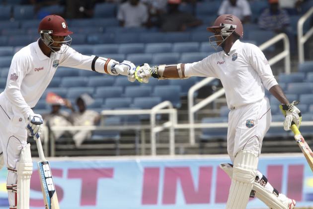 West Indies captain Denesh Ramdin, left, and batting partner Shivnarine Chanderpaul fist bump with gloved hands during the third day of their first cricket Test match against New Zealand in Kingston, Jamaica, Tuesday, June 10, 2014. (AP Photo/Arnulfo Franco)